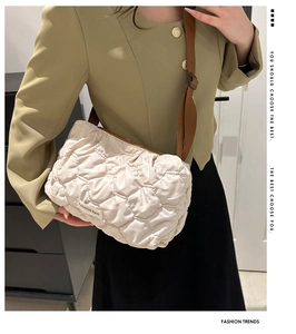Detail of off-white quilted shoulder bag with brown strap and Fashion Bag woven label