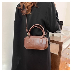 Brown vintage leather bowling bag with top handles shown on model for size and style