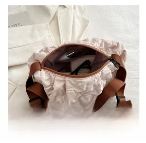 Spacious interior of beige quilted cloud bag showing room for glasses and phone