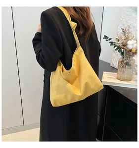 Close-up of ginger yellow hobo tote bag with decorative shoulder strap knot detail
