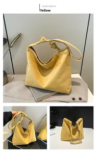 Detail view of yellow suede tote bag featuring a knotted shoulder strap and magnetic closure