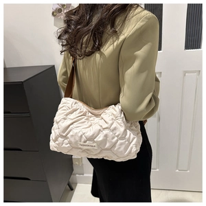Close-up of cream quilted tote bag with rhombus stitching and fashion tag detail