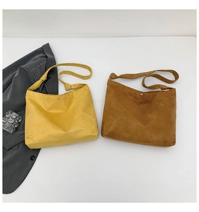 Flat lay of mustard and brown matte suede tote bags with knotted strap details
