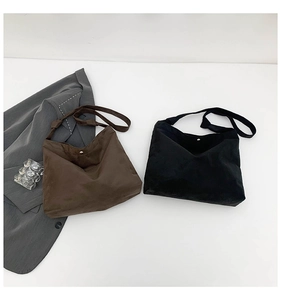 Close-up of matte suede tote bags in brown and black with knotted shoulder straps