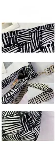 Detail view of canvas tote bag showing black geometric print fabric and gold metal zipper