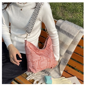 Detail of pink geometric canvas tote bag featuring black and white checkered wide strap