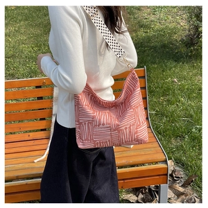 Detail of pink canvas tote bag with abstract white lines and patterned shoulder strap