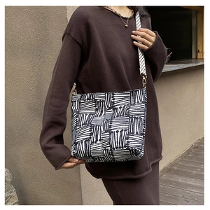 Detail of canvas tote bag with abstract black and white patterns on a female model