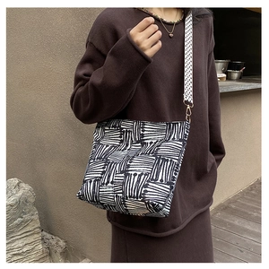 Close-up of canvas crossbody bag featuring black and white geometric ethnic patterns