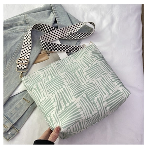 Detail of mint green canvas tote bag with clover pattern wide shoulder strap