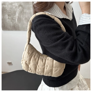 Sac sous le bras matelassé beige porté par un mannequin montrant la texture douce