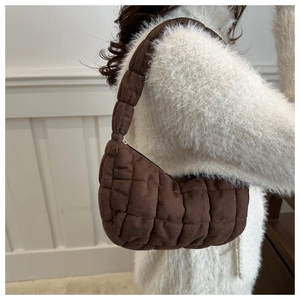 Gros plan du sac à bandoulière marron foncé matelassé avec surpiqûres carrées