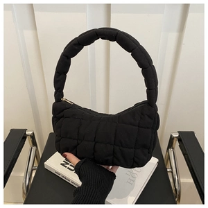 Gros plan détaillé du sac à main matelassé noir avec texture de couture et fermeture éclair