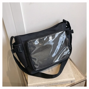 Black nylon messenger ita bag with transparent window for pins on vintage books background