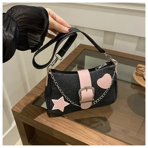 Dettaglio della borsa a tracolla in denim con patch in pelle rosa e catena in metallo