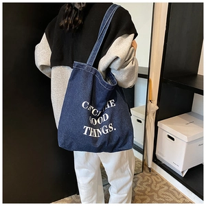 Detail of a large denim tote bag with Catch the Good Things white text print