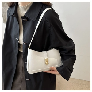 Close-up of minimalist white leather baguette bag with a premium gold metallic buckle