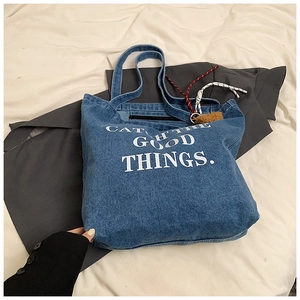 Blue denim tote bag detail with Catch The Good Things text and colorful charms