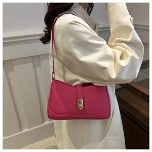 Fashionable magenta underarm bag with gold buckle on a model in a beige coat