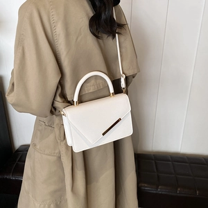 White lychee pattern crossbody bag with gold accents and a slender shoulder strap