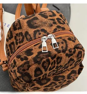 Detail view of smooth metal zippers and leopard print plush fabric on the backpack