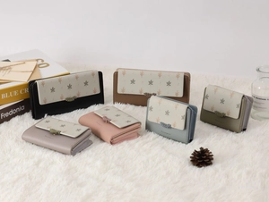 Collection de portefeuilles en cuir colorés avec motifs de feuilles sur un tapis blanc
