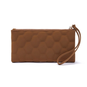 Detail of brown quilted honeycomb pattern on women's long wallet with wristlet strap