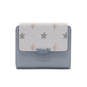 Close-up of small blue and beige bi-color wallet with leaf print and leather texture