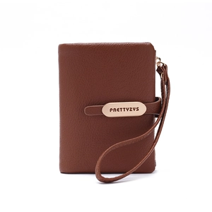 Detail of brown litchi pattern leather wallet with wrist strap and gold logo plate