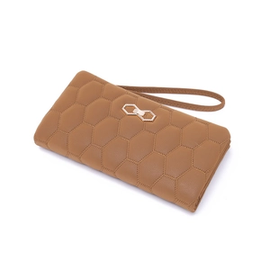Detail of brown quilted honeycomb texture on long wallet with gold hexagonal clasp