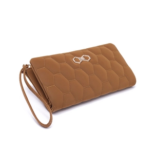 Detail view of brown long wallet with quilted honeycomb texture and metal buckle