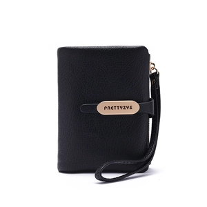 Detail view of black lychee-grain wallet with golden logo plate and wrist strap