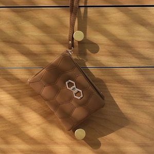 Détail d'un porte-monnaie marron en cuir PU matelassé avec un nœud en cristal brillant