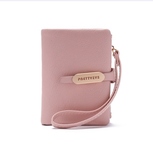 Detail view of pink pebbled leather texture and gold-tone logo hardware on women's wallet