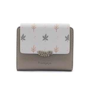 Close-up of floral print short wallet with pebble grain leather and leaf metal clasp
