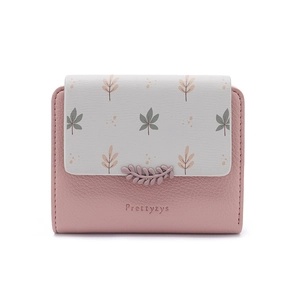 Detailed view of leaf pattern print and 3D leaf charm on pink short folding wallet