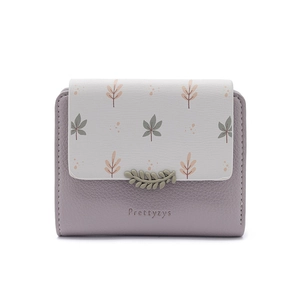 Detail view of small PU leather wallet with floral leaf pattern and leaf shaped metal clasp