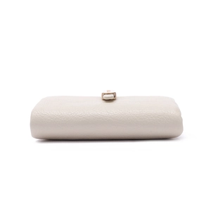 Detail of cream white pebbled leather wallet with elegant light gold metal snap button