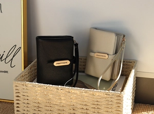 Detail of lychee pattern PU leather wallet with wrist strap and metal zipper hardware