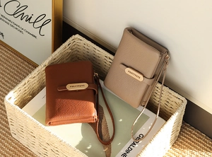 Detail of short leather wallets with litchi texture and wrist strap for women