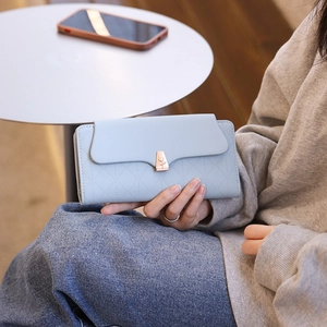 Close-up of light blue quilted PU leather wallet with a gold flower metal clasp
