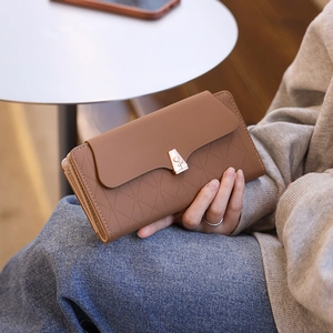 Detail of long brown PU leather wallet with tulip metal buckle and geometric texture