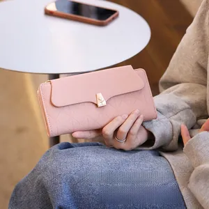 Detail of light pink quilted leather wallet with elegant gold tulip-shaped metal clasp