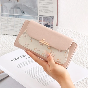 Detail view of pink and beige patchwork wallet with flower pattern and rabbit buckle