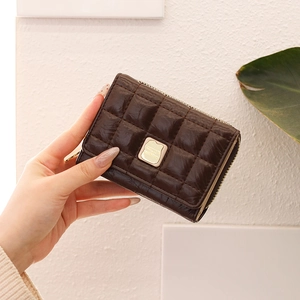 Close-up of a brown quilted PU leather accordion wallet with gold metal logo detail