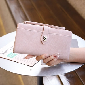 Close-up of light pink PU leather wallet featuring metal logo and convenient wrist strap