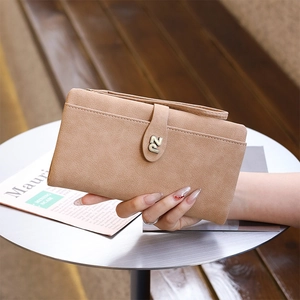 Close-up of light tan long faux suede wallet with hand strap and metal PZ hardware detail