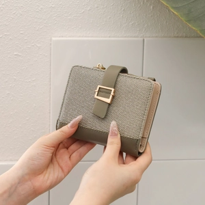 Detail van groen PU-leer en beige visgraatweefsel stiksels op een dames portemonnee