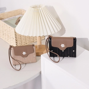 Close-up of floral print PU leather wallets in beige and black with floral ornament