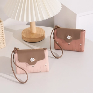 Close-up of PU leather wallets with small flower buckle, wrist strap and zipper closure